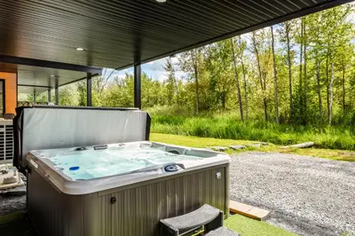 a hot tub in the middle of a yard at Le Memph Hirondelle spacious comfortable condo cottage eco responsible 3 bedrooms - hot tub & pool Memphrémagog Lake in Magog-Orford
