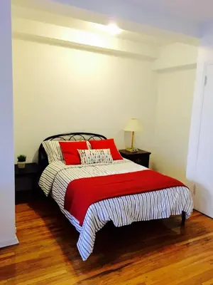 a bedroom with a bed with red pillows on it at Stylish Montreal Apartment: Comfortable Stay in the Golden Square Mile in Montréal