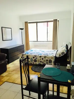 a living room with a bed and a table and a table sidx sidx at Stylish Montreal Apartment: Comfortable Stay in the Golden Square Mile in Montréal