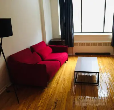 a living room with a red couch and a table at Stylish Montreal Apartment: Comfortable Stay in the Golden Square Mile in Montréal