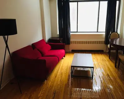 a living room with a red couch and a table at Stylish Montreal Apartment: Comfortable Stay in the Golden Square Mile in Montréal
