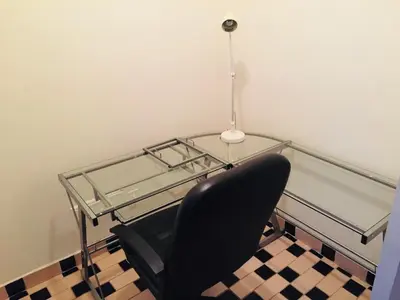a glass table with a black chair and a lamp at Stylish Montreal Apartment: Comfortable Stay in the Golden Square Mile in Montréal
