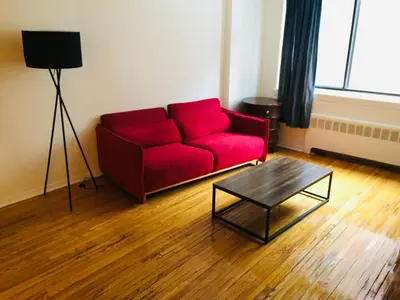 a red couch in a living room with a coffee table at Stylish Montreal Apartment: Comfortable Stay in the Golden Square Mile in Montréal