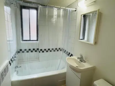 a white bathroom with a tub and a sink at Stylish Montreal Apartment: Comfortable Stay in the Golden Square Mile in Montréal