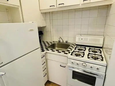 a kitchen with a white stove and a sink at Stylish Montreal Apartment: Comfortable Stay in the Golden Square Mile in Montréal
