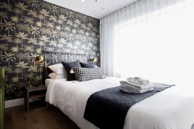 a bedroom with a bed with black and gold wallpaper at 6768 - 202 Amazing mini studio with full kitchen by Denstays in Montréal