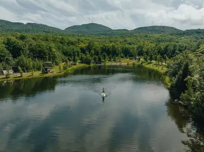 a person in a paddle boat on a river at Cottage 2 de la Chute in Eastman