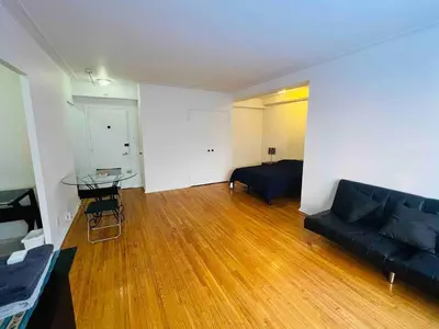 a living room with a black couch and a table at Stylish Montreal Apartment: Comfortable Stay in the Golden Square Mile in Montréal