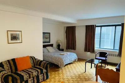 a living room with a couch and a bed at Stylish Montreal Apartment: Comfortable Stay in the Golden Square Mile in Montréal