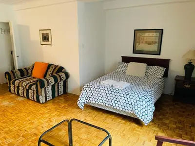 a living room with a bed and a couch at Stylish Montreal Apartment: Comfortable Stay in the Golden Square Mile in Montréal