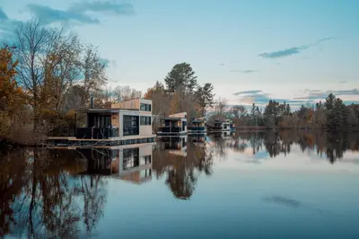 a house on a dock on a body of water at MiniBora Le beaumier - Cantons-de-l'Est in Bury