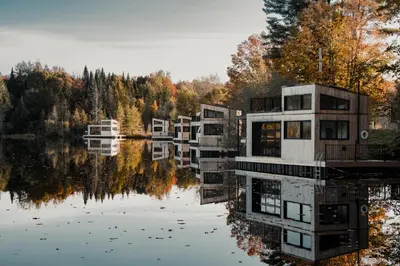 a row of houses sitting on a lake at MiniBora Le beaumier - Cantons-de-l'Est in Bury