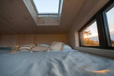 a bedroom with a large bed with a window at MiniBora Le cumulus - Cantons-de-l'Est in Bury