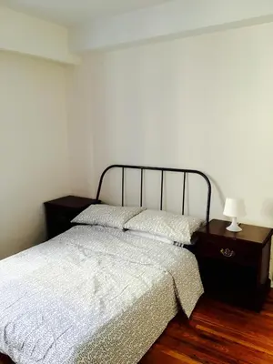 a bedroom with a bed and a table with a lamp at Stylish Montreal Apartment: Comfortable Stay in the Golden Square Mile in Montréal
