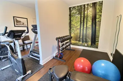 a room with a gym with exercise equipment and a window at Superbe condo - Navette de Ski Gratuite #102 in Bromont