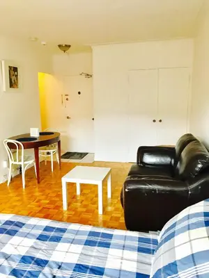 a living room with a black leather couch and a table at Stylish Montreal Apartment: Comfortable Stay in the Golden Square Mile in Montréal