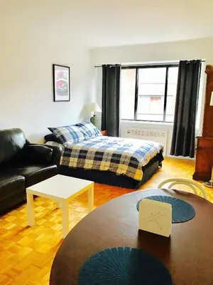 a living room with a bed and a couch at Stylish Montreal Apartment: Comfortable Stay in the Golden Square Mile in Montréal