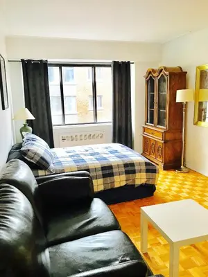 a living room with a bed and a couch at Stylish Montreal Apartment: Comfortable Stay in the Golden Square Mile in Montréal