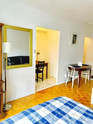 a room with a bed and a table and a mirror at Stylish Montreal Apartment: Comfortable Stay in the Golden Square Mile in Montréal