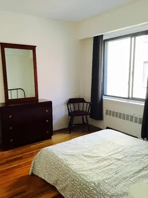 a bedroom with a bed and a dresser and a mirror at Stylish Montreal Apartment Comfortable Stay in the Golden Square Mile in Montréal