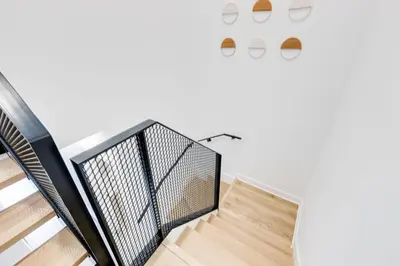 a staircase in a house with a white wall at Le Mile End by M11 - Luxurious Two-Floor 1BDR Loft in Montréal