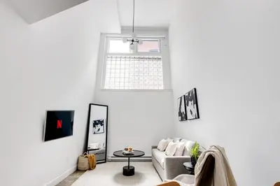 a living room with a couch and a window at Le Mile End by M11 - Luxurious Two-Floor 1BDR Loft in Montréal