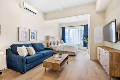 a living room with a blue couch and a bed at Central King Studio in Montréal