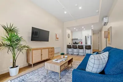 a living room with a blue couch and a tv at Central King Loft in Montréal