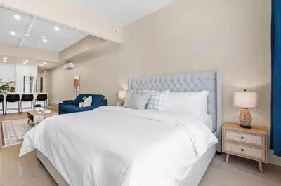 a bedroom with a white bed and a blue couch at Central King Loft in Montréal