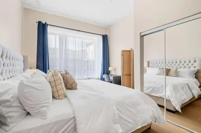 a bedroom with a large white bed and a mirror at Central King Loft in Montréal