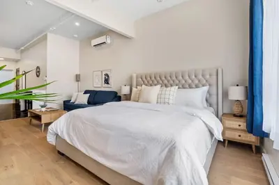 a bedroom with a large bed and a blue couch at DownTown King Suite in Montréal