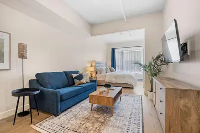 a living room with a blue couch and a table at City Center King Loft in Montréal