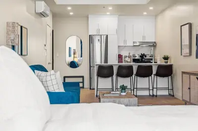 a living room with a blue couch and a kitchen at City Center King Suite in Montréal