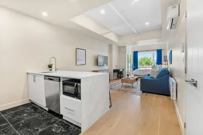 a kitchen with a counter and a living room at DownTown King Loft in Montréal
