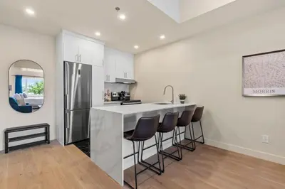 a kitchen with a bar with stools and a refrigerator at DownTown King Loft in Montréal