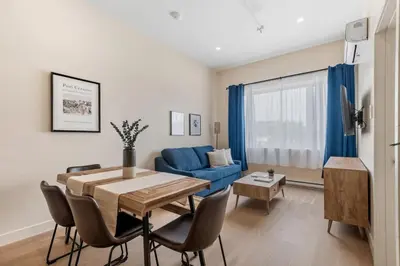 a living room with a table and a blue couch at Stylish 2BR Retreat in Montréal