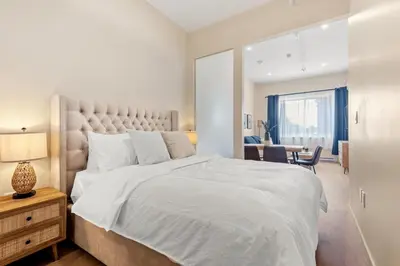a bedroom with a large white bed and a desk at Stylish 2BR Retreat in Montréal