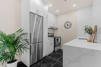 a kitchen with a stainless steel refrigerator and a clock at Stylish 2BR Retreat in Montréal