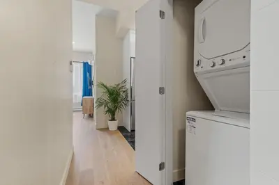 a kitchen with white appliances and a plant in a hallway at Stylish 2BR Retreat in Montréal