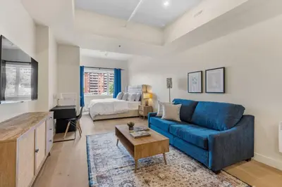 a living room with a blue couch and a bed at Luxe DownTown King Suite in Montréal