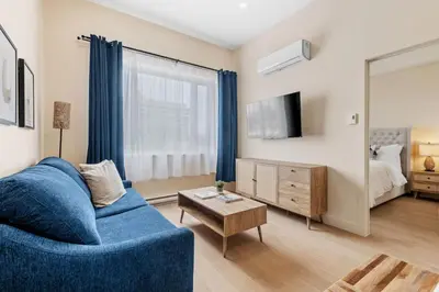 a living room with a blue couch and a mirror at Downtown 2BR condo in Montréal