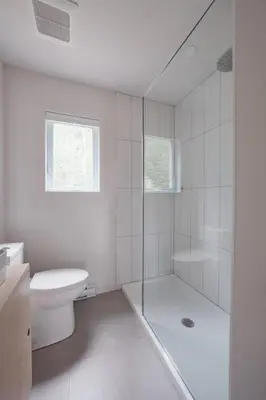 a white bathroom with a shower and a toilet at Chalet 2 OST Shefford in Shefford
