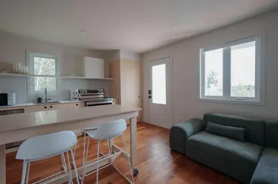 a kitchen and living room with a green couch at Chalet 4 OST Shefford in Shefford