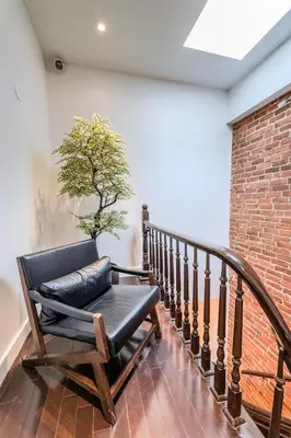 a chair on a staircase with a tree on the wall at Self Check-In Boutique Hotel - Quartier latin - Room 202 in Montréal