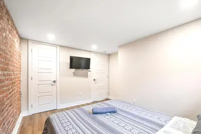 a bedroom with a bed and a tv on the wall at Fancy 3 BDR in Heart of Plateau B in Montréal