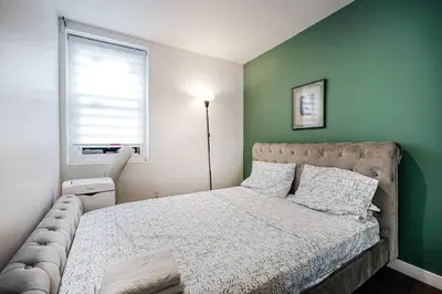 a bedroom with a bed with a green wall at Bienvenue dans votre havre de paix à Griffintown in Montréal
