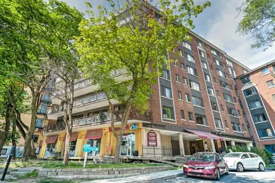 a red car parked in front of a building at Stylish Montreal Apartment Comfortable Stay in the Golden Square Mile in Montréal