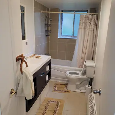 a bathroom with a toilet and a sink and a shower at Chambre vu à couper le souffle in Montréal