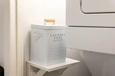 a white trash can sitting on a shelf next to a refrigerator at #7 - Charming Studio - Self Check in - Plateau - St-Denis - AC - TV in Montréal