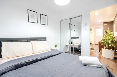 a bedroom with a large bed and a living room at Cozy 2-Bedroom in Griffintown in Montréal